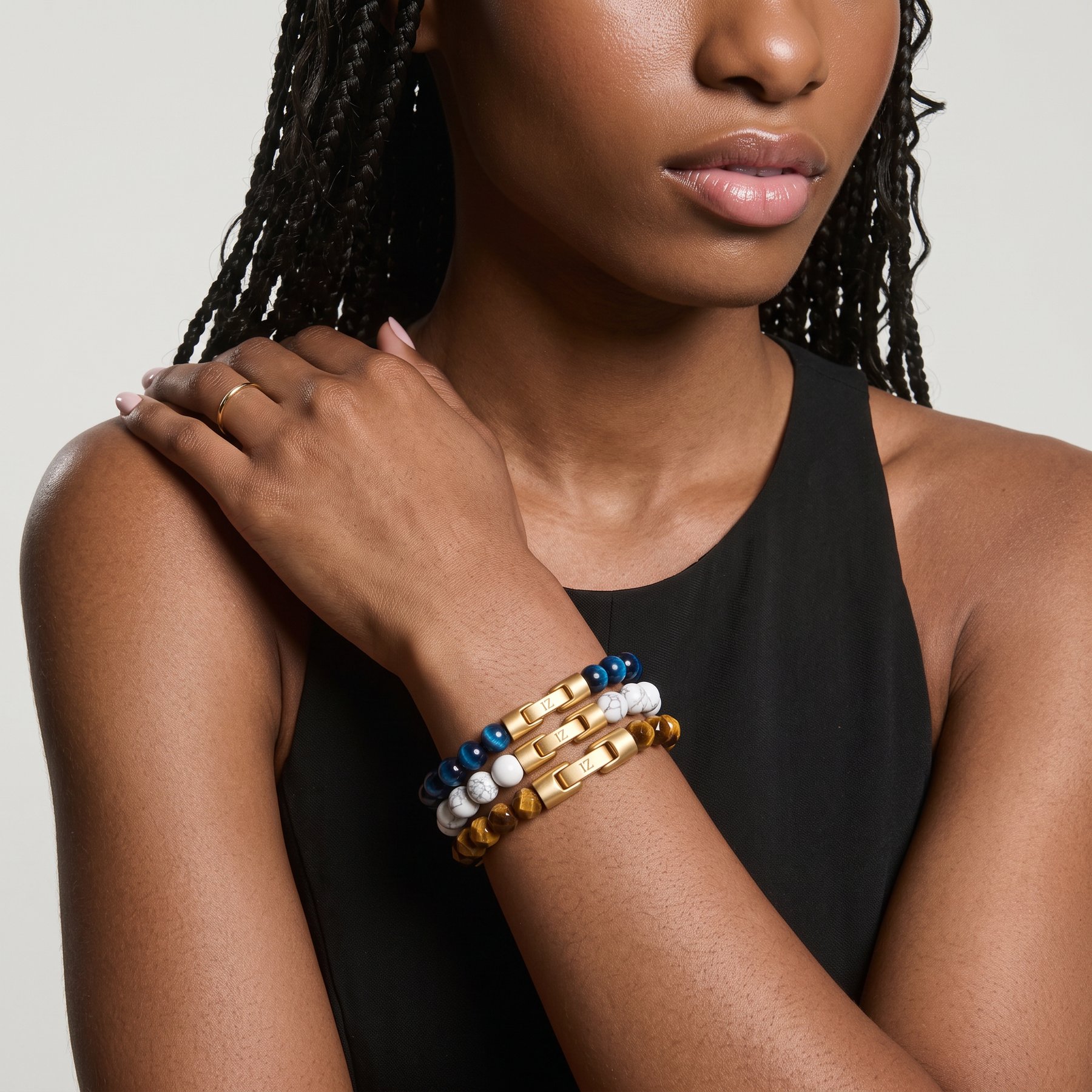 Tide, Chalk and Honey bracelets stacked on a wrist, hand on the shoulder