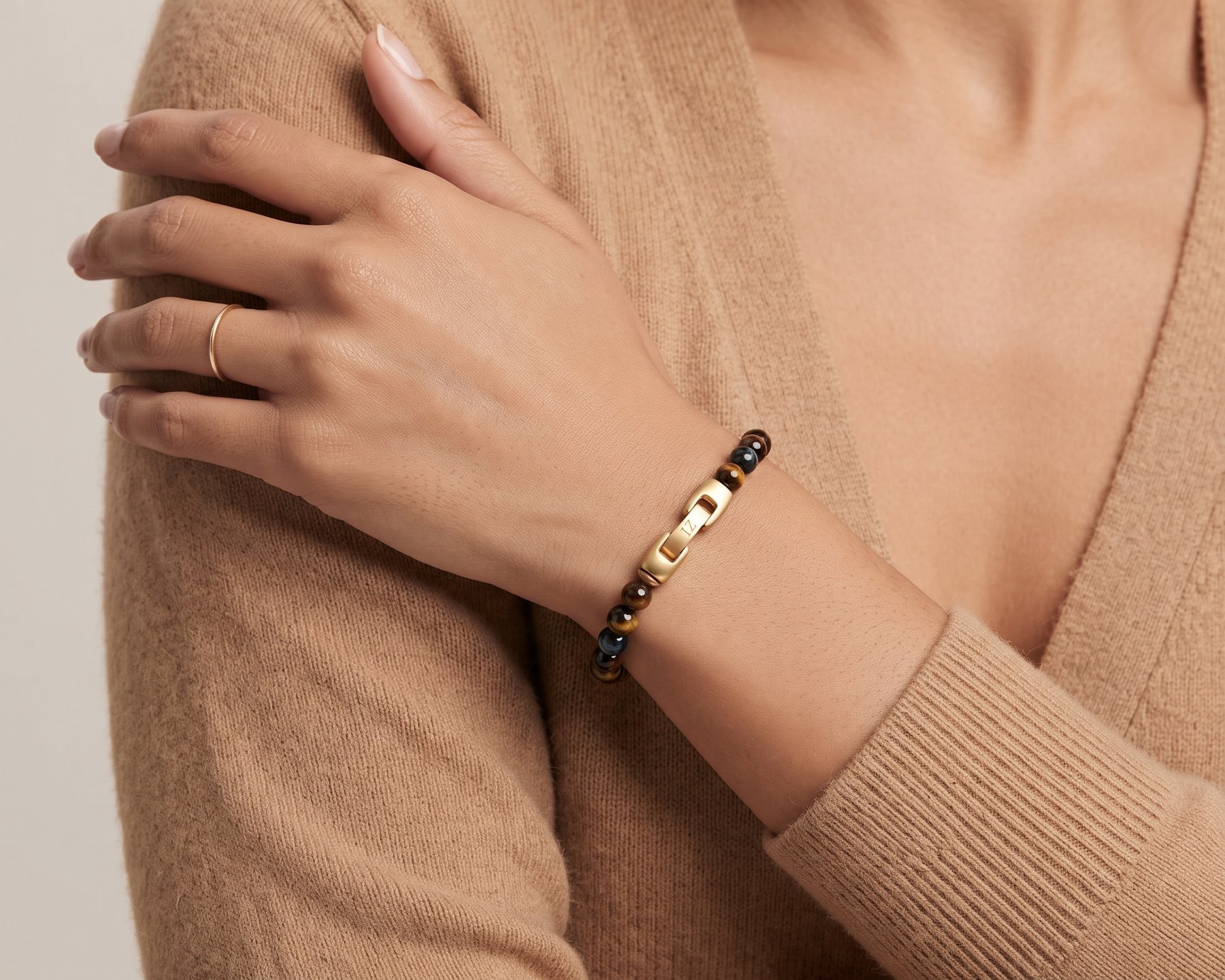 Dusk tiger's eye bracelet, hand on a camel cardigan sleeve
